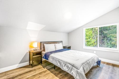 a white bedroom with a bed and a window at Eagles Nest in Sagle