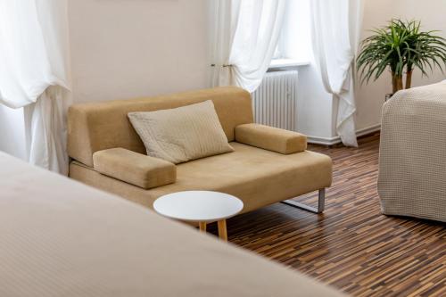 a living room with a couch and a table at Palác Daun - Studio Apartments in Znojmo