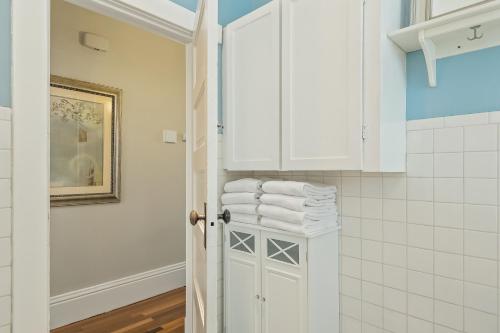 a white bathroom with white towels on a cabinet at Dreamy Abode in Spokane