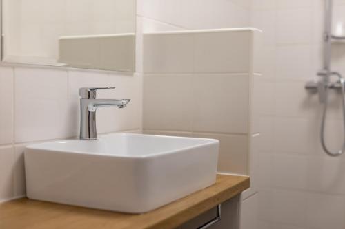 a white sink in a bathroom with a shower at Palác Daun - Studio Apartments in Znojmo
