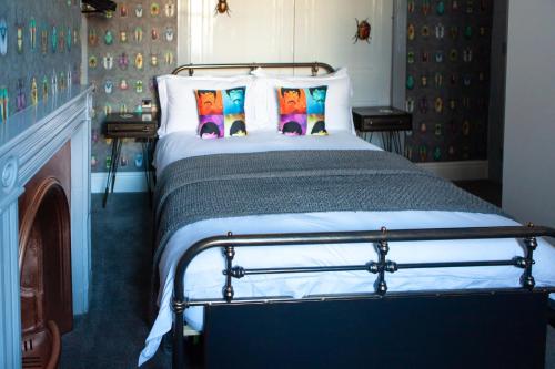 Cama en habitación con chimenea y cama con almohadas en The View on the terrace en Weymouth