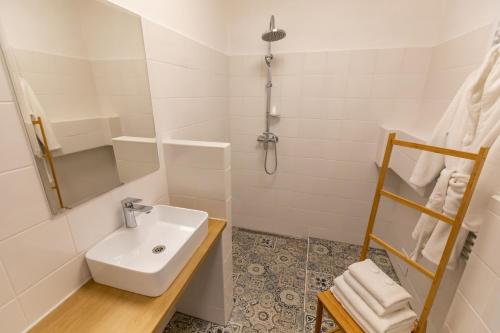a white bathroom with a sink and a shower at Palác Daun - Studio Apartments in Znojmo