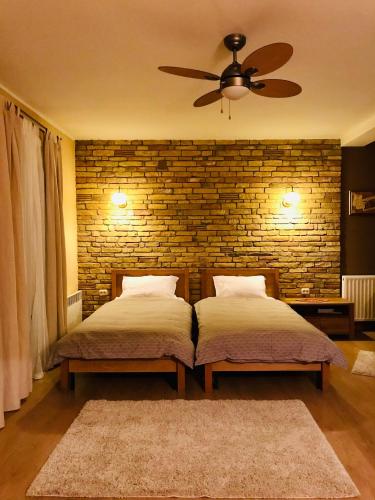 two beds in a bedroom with a brick wall at VNVP Amber in Štip