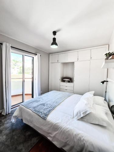biała sypialnia z dużym łóżkiem i oknem w obiekcie Santa Luzia's Pearl V - Two Bed Apartment w Funchal