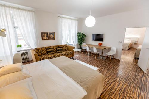 a bedroom with a bed and a living room at Palác Daun - Studio Apartments in Znojmo