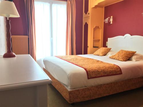a hotel room with a bed and a window at Hôtel Restaurant Le Grillon in Chambon-sur-Lac
