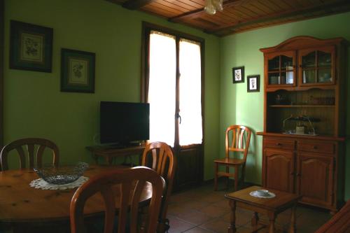 a dining room with a table and a television at Apartamentos Casa Gallan in Sarvisé