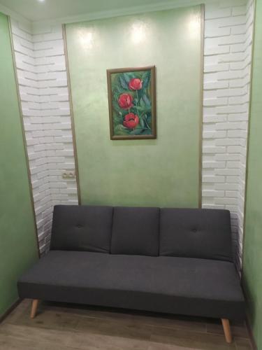 a couch in a room with a painting on the wall at Апартаменты по Панаса Мирного. in Khmelʼnytsʼkyy