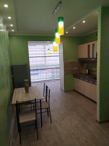 a kitchen and dining room with a table and chairs at Апартаменты по Панаса Мирного. in Khmelʼnytsʼkyy