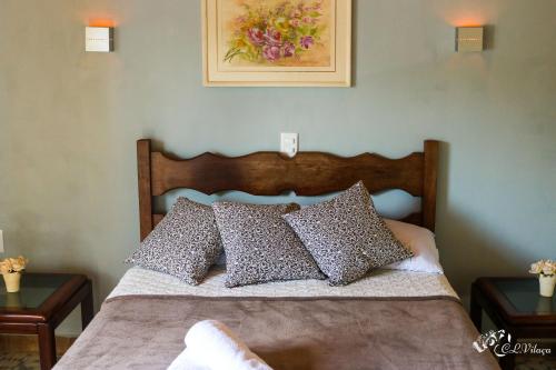 a bedroom with a bed with pillows on it at Pousada e Restaurante Victórios in Caeté