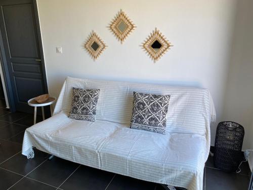 a white couch in a room with mirrors on the wall at Gîte Le Moringa in Saint-Pierre