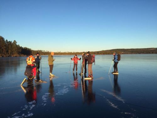 a group of people standing on a lake with skis at Bakgården i Revsund in Gällö