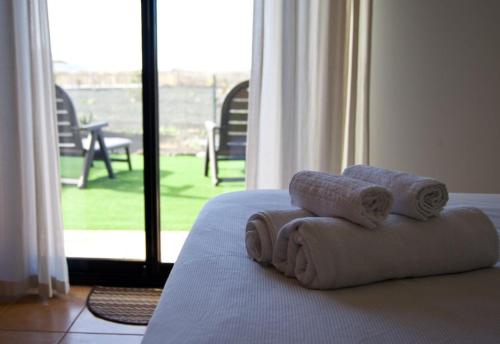 a pile of towels sitting on top of a bed at The Blue Torrent, perfect for relaxing getaway in La Oliva