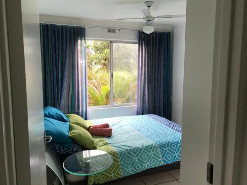 a small bedroom with a bed and a window at 219 Laguna la Crete in Margate