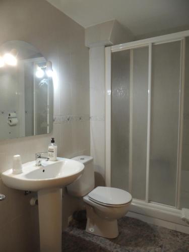 a bathroom with a toilet, sink, and shower at Hostal Cumbre in Zaragoza