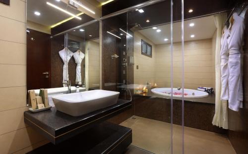 a bathroom with a sink and a bath tub at Maliekal Heritance Cherai Beach Cochin in Cherai Beach