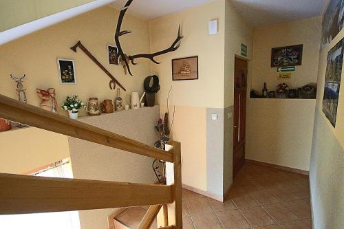 a room with a staircase with antlers on the wall at Leśne Zacisze in Murzasichle