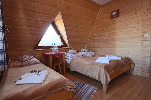 a room with two beds in a log cabin at Leśne Zacisze in Murzasichle
