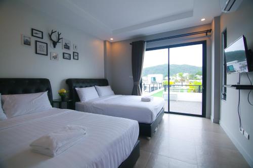 um quarto de hotel com duas camas e uma varanda em บ้าน Spring Vintage Pool Villa ใจกลางเมืองหัวหิน ใกล้หาด em Hua Hin