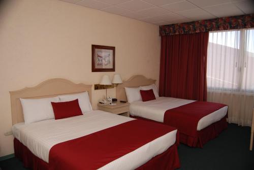 a hotel room with two beds and a window at Quality Inn Aguascalientes in Aguascalientes