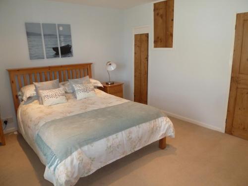 a bedroom with a bed with a wooden headboard at Seapinks Cottage in Portland