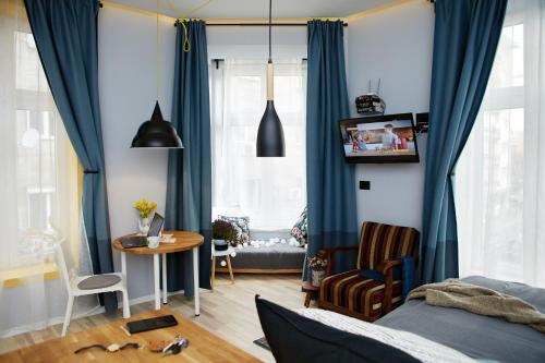 1 dormitorio con cortinas azules, mesa y cama en Courthouse Apartments Slavi, en Sofía