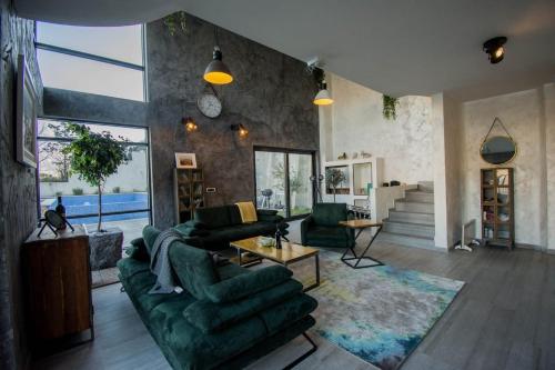 a living room with a green couch and chairs at Seafront Villa with Private Pool & Beach in Kotor Bay, Villa Viborg in Kotor