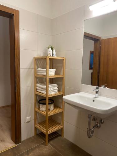 La salle de bains est pourvue d'un lavabo et d'un miroir. dans l'établissement Ferienwohnung neben dem Schloss Porcia, à Spittal an der Drau