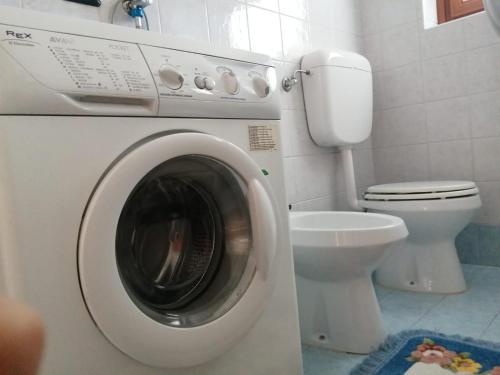 lavatrice in bagno con servizi igienici di Casa Minela a Falcade