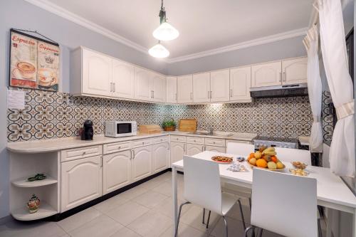 una cucina con armadi bianchi e un tavolo con frutta di Bambus House Blue a Quarteira