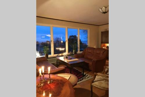 a living room with a couch and a table at Villa med fantastisk utsikt in Båstad