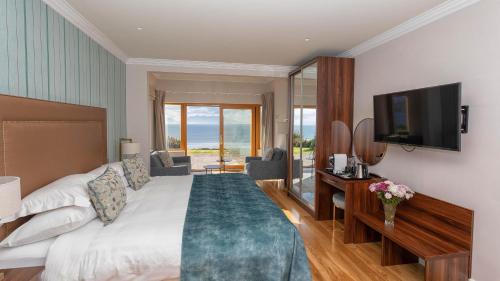 ein Hotelzimmer mit einem Bett und einem TV in der Unterkunft Inch Beach House B&B in Inch