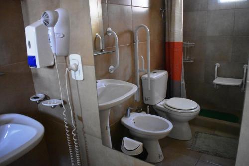 a bathroom with a toilet and a sink with a phone at Complejo Solar Apart in Villa Regina