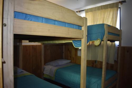 a couple of bunk beds in a room at Cabañas y Tinajas Borde río in Licán Ray