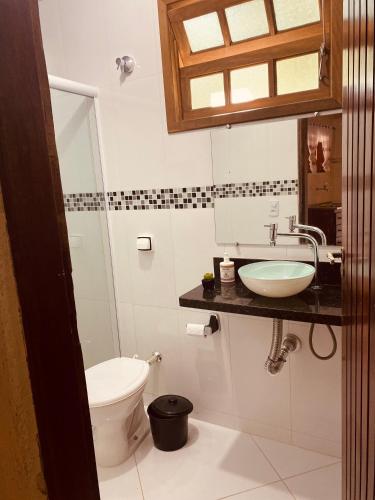 a bathroom with a toilet and a sink at Mandacaru Chalés e Suítes Itamambuca in Ubatuba