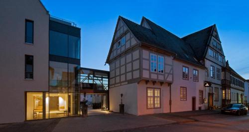 a building with a black roof on a street at Hotel Stadtpalais in Lemgo