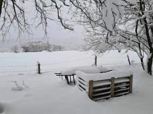 a snow covered park with benches and a fence at B&B Au Coq en Pate in Jalhay