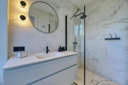 een witte badkamer met een wastafel en een spiegel bij Villa Berry Centre Deauville - Chic & Stylée - Magnifique Jardin in Deauville