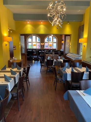 a restaurant with tables and chairs and a chandelier at Hotel Restaurant Nassauer Löwen in Nassau