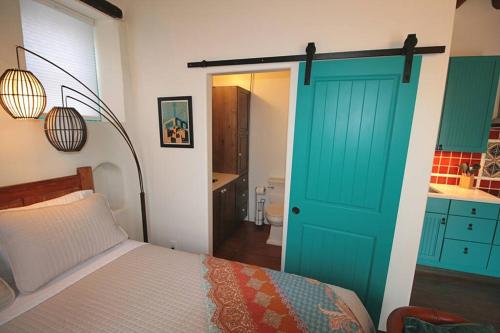 a bedroom with a bed and a blue door at Closson Studio - Stylish - Near Plaza - Queen bed in Santa Fe