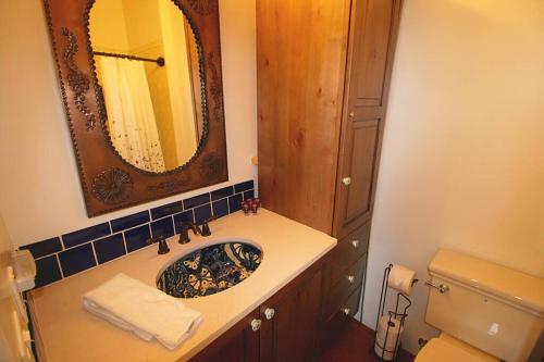 a bathroom with a sink and a mirror and a toilet at Closson Studio - Stylish - Near Plaza - Queen bed in Santa Fe