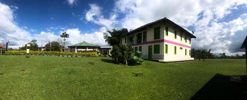 a house in the middle of a green field at Finca Hotel el Rocio in Circasia