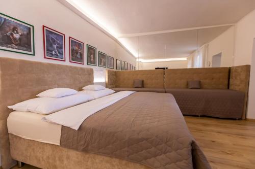 a bedroom with a large bed and a couch at Palác Daun - Studio Apartments in Znojmo