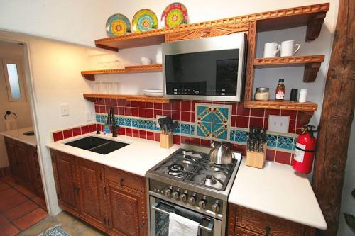 a kitchen with a stove and a microwave at Closson Getaway - Courtyard - Railyard and Plaza in Santa Fe