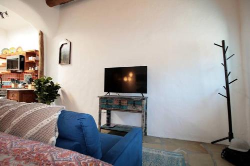 a living room with a blue couch and a tv at Closson Getaway - Courtyard - Railyard and Plaza in Santa Fe