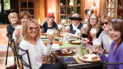 a group of women sitting at a table with drinks at Hacienda Jimenita Wildlife Reserve in Puembo