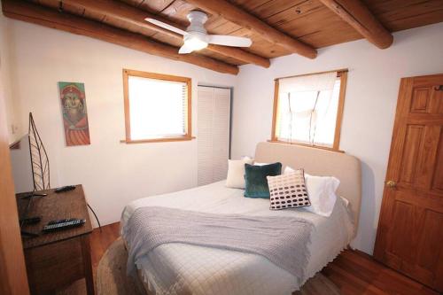 a bedroom with a bed with a ceiling fan at Galisteo Getaway - Courtyard - Near Railyard in Santa Fe