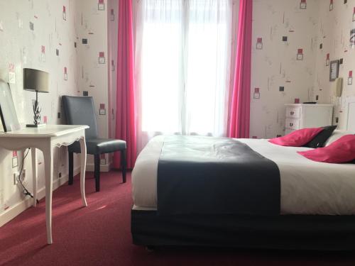 a bedroom with a bed and a desk and a window at Hôtel Restaurant Le Grillon in Chambon-sur-Lac