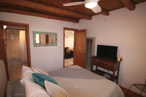 a living room with a bed and a television at Galisteo Getaway - Courtyard - Near Railyard in Santa Fe