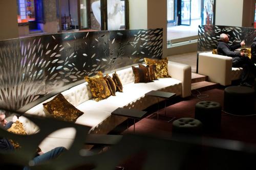 a living room with a couch with gold pillows at Home Hotel Folketeateret in Oslo